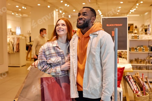 Preview: awesome couple looking up, looking at big sale