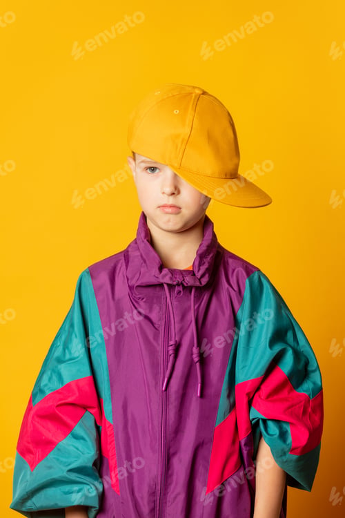 Preview: Stylish kid boy in 80s sport suit and cap on yellow background