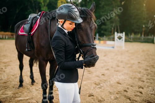 Preview: Young woman in helmet hugs horse, horseback riding