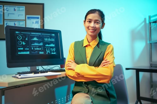 Preview: An Asian businesswoman analyzes digital charts on a computer screen, reviewing performance reports