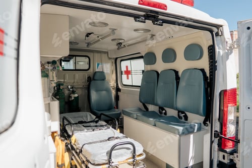Preview: Closeup shot of the open back door of ambulance and showing the patient bed, chairs, oxygen cylinder