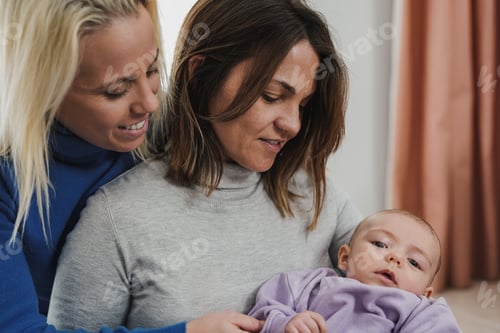 Preview: Loving women embrace their infant child indoors