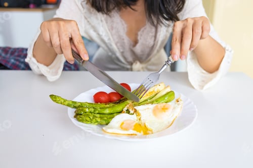 Preview: Fried asparagus with eggs and tomatoes in a plate on white background. Healthy breakfast.