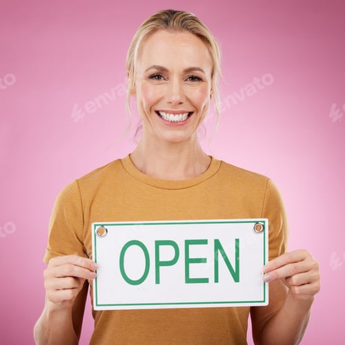 Preview: Woman, open sign and portrait in studio, announcement or welcome on pink background. Happy female m