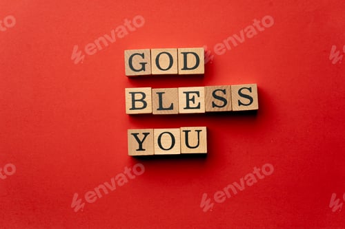 Preview: a yellow warm background without shadows wooden cubes with black letters laid out word god bless you