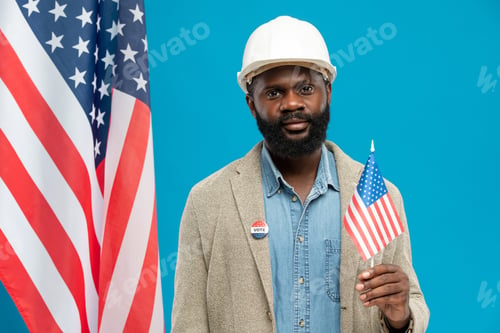 Preview: Contemporary African builder in helmet and formalwear holding American flag