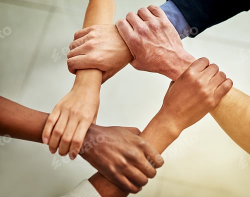 Preview: Cropped shot of a group of businesspeople linking their arms in solidarity