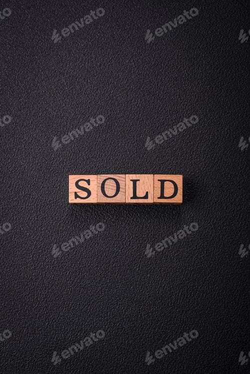 Preview: The inscription Sold made of wooden cubes on a plain background
