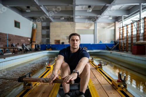 Preview: Dedicated man rower practices paddling in pool simulator, academic sports and athletic pursuit
