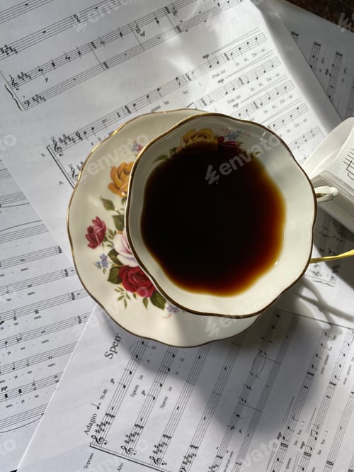 Preview: Sheet music with coffee cup in sunlight