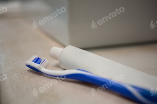Preview: Toothpaste tube and toothbrush in bathroom
