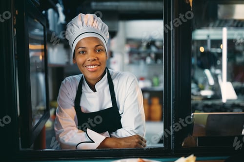 Preview: African American female chef looking through window of food truck.