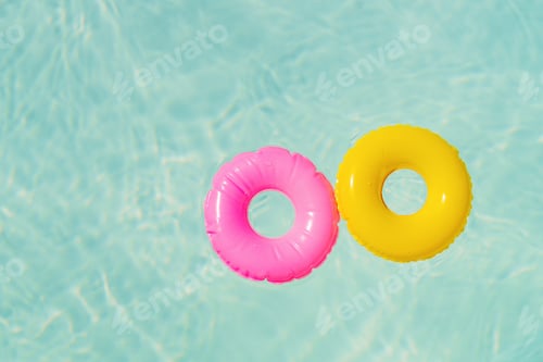 Preview: Colorful pool floats create a fun atmosphere in a sunny swimming pool. Copy space background.