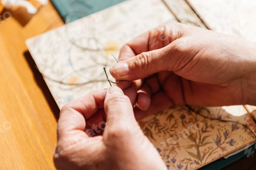 Preview: Unrecognizable woman sitting in daylight with thread and needle