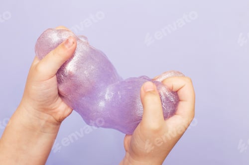 Preview: Making slime at home. child stretching colorful slime. DIY concept.