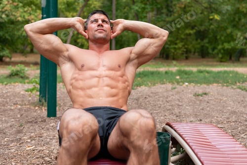 Preview: A fitness enthusiast works on his core strength, doing crunches on a sit-up board