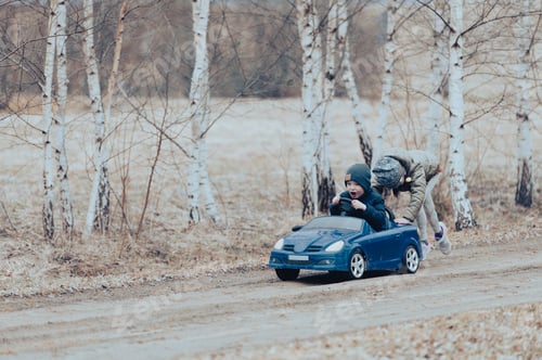 Preview: Two happy kids having fun drive a blue toy car, road trip adventure concept