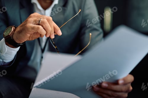 Preview: Close up of businessman analyzing reports in the office.