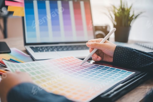 Preview: Graphic designer architects who work with laptops and color comparison tables for design work.