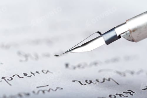Preview: Writing tool rests on paper with words in background during a quiet moment of reflection