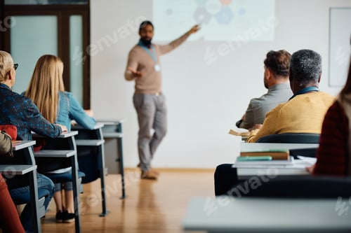 Preview: Rear view of adult students attending education training class in lecture hall.