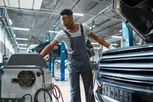 Preview: Male worker refills air conditioner, car service