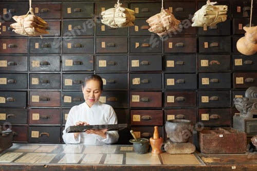Preview: Woman counting ingredients in apothecary