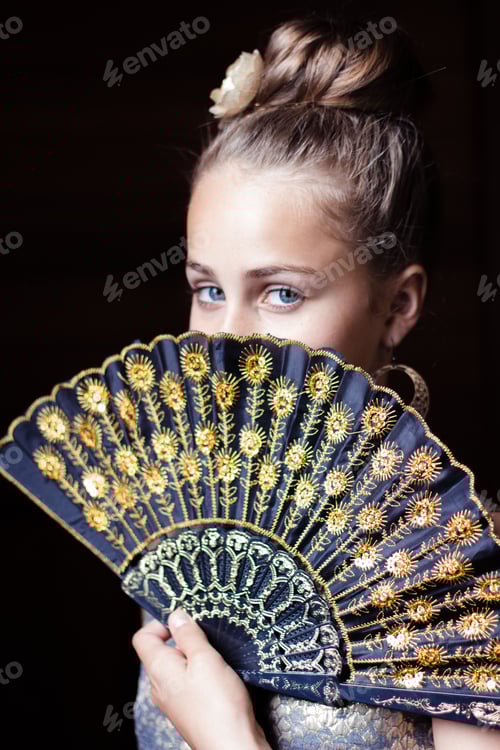 Preview: Young lady looking over a delicate fan