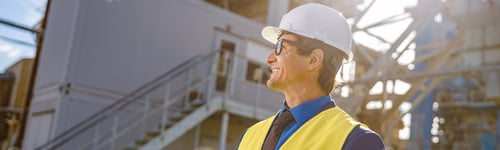 Preview: Cheerful male engineer doing paperwork outdoors at factory