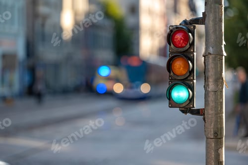 Preview: view of city traffic with traffic lights, in the foreground a semaphore with a green light, closeup