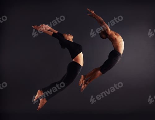 Preview: A female and male contemporary dancer performing a dramatic pose in front of a dark background