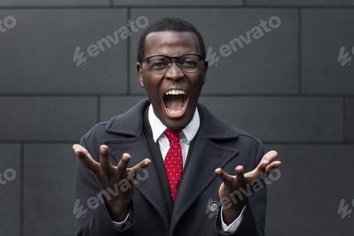 Preview: Young attractive handsome African businessman screams and shouts desperately