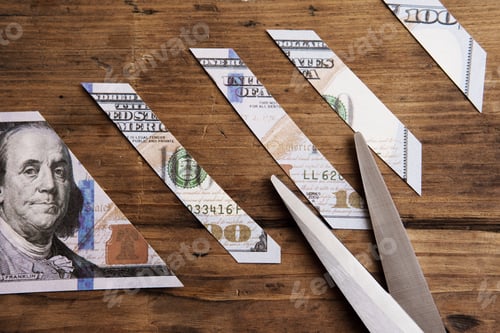 Preview: One hundred dollar bill is sliced into pieces with steel scissors.