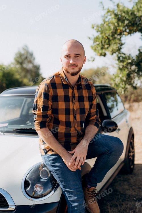 Preview: Guy in a plaid shirt next to a white car