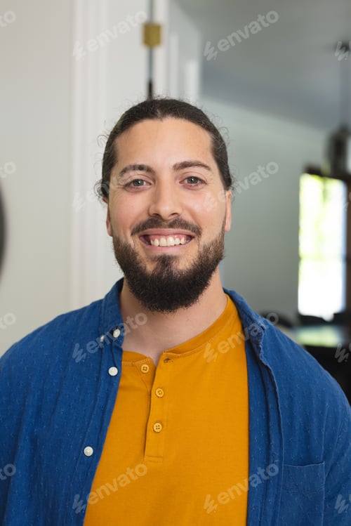 Preview: Portrait of happy caucasian man with beard standing and smiling in sunny house