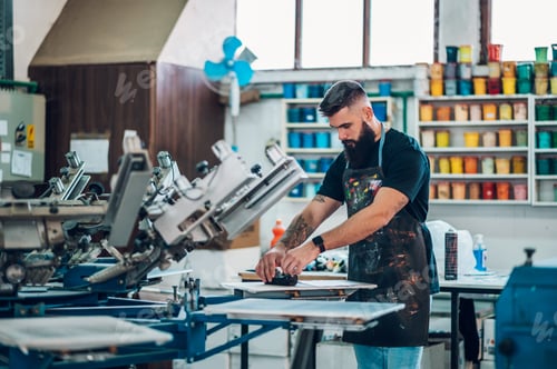 Preview: Male worker preparing screen printing film in a workshop