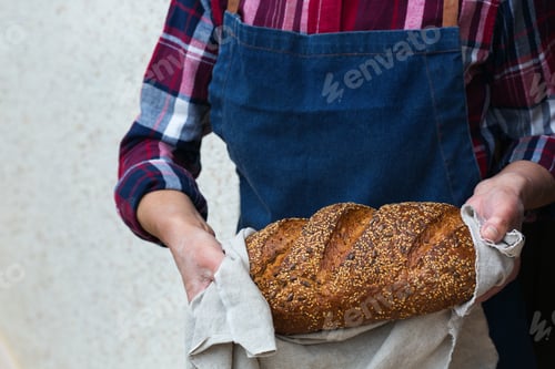 Preview: Fresh loaf of homemade rye bread in woman hands
