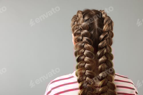 Preview: Woman with braided hair on grey background, back view. Space for text