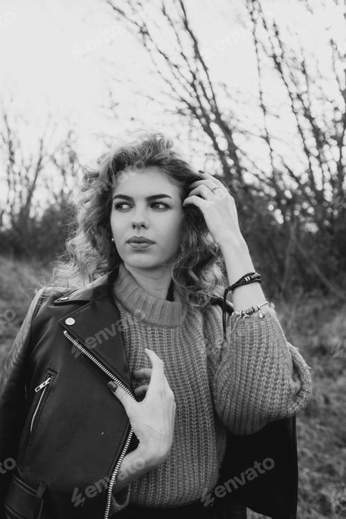 Preview: young curly girl in an orange sweater against the backdrop of autumn nature