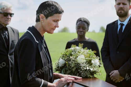 Preview: Middle Aged Caucasian Woman Mourning Beside Coffin during Outdoor Funeral