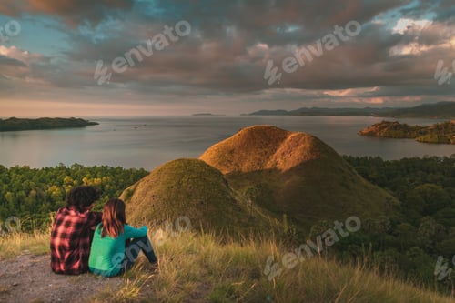 Preview: couple sitting on the hills enjoy sunset and sea together