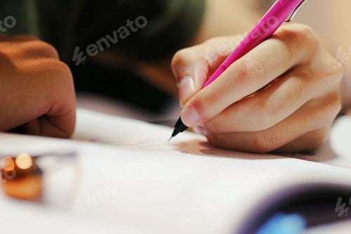 Preview: People holding pink pen in hand writing on document paper on desk closeup macro blur background