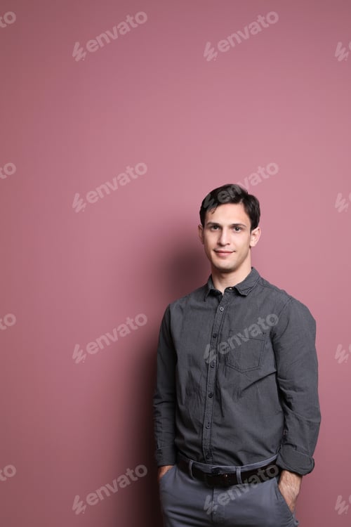 Preview: Portrait of confident young man on color background