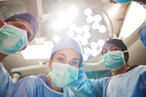 Preview: Low angle view of surgeons over the operating table