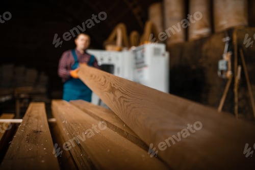 Preview: Carpenter works on woodworking machine, lumber
