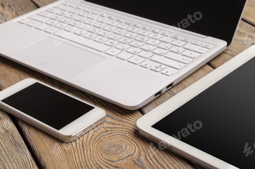 Preview: Open laptop with digital tablet and white smartphone close up top view