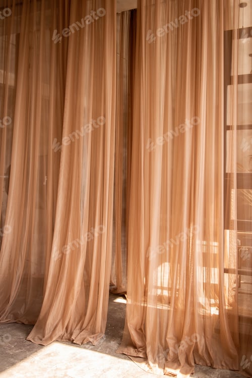 Preview: Airy peach tulle hangs as an interior decoration. Light fabrics are illuminated by the sun's rays