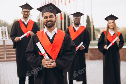 Preview: Diverse Group of Happy Graduates in Cap and Gown Celebrating Achievement Outdoors