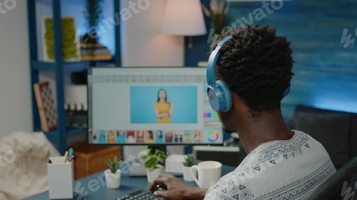 Preview: Photographer retouching pictures on computer and wearing headphones
