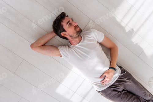 Preview: Man lying on floor experiencing skin allergy symptoms